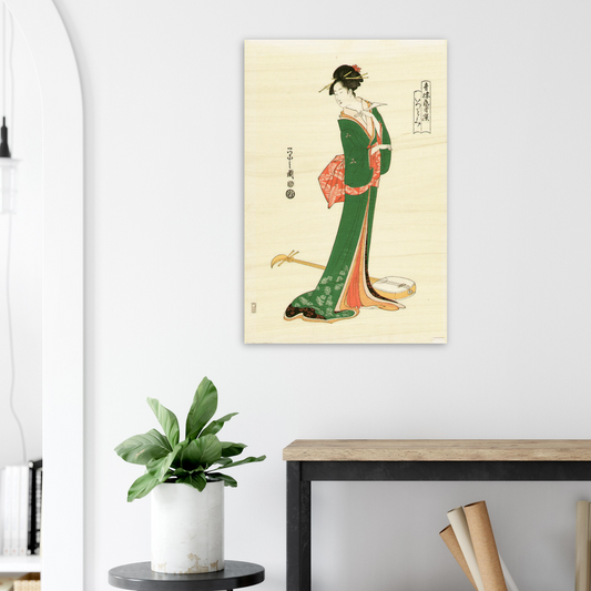 Framed artwork of a traditional Japanese geisha on a wall above a desk with a plant.