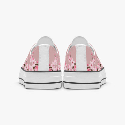 Pair of sneakers with pink floral pattern on a white background