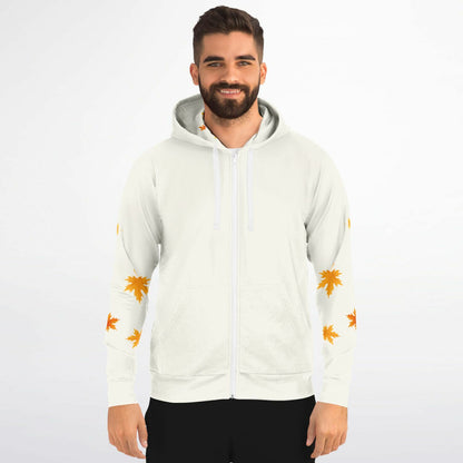 A man wearing a white zip-up hoodie with orange maple leaf prints on the sleeves, photographed against a plain light gray studio background.