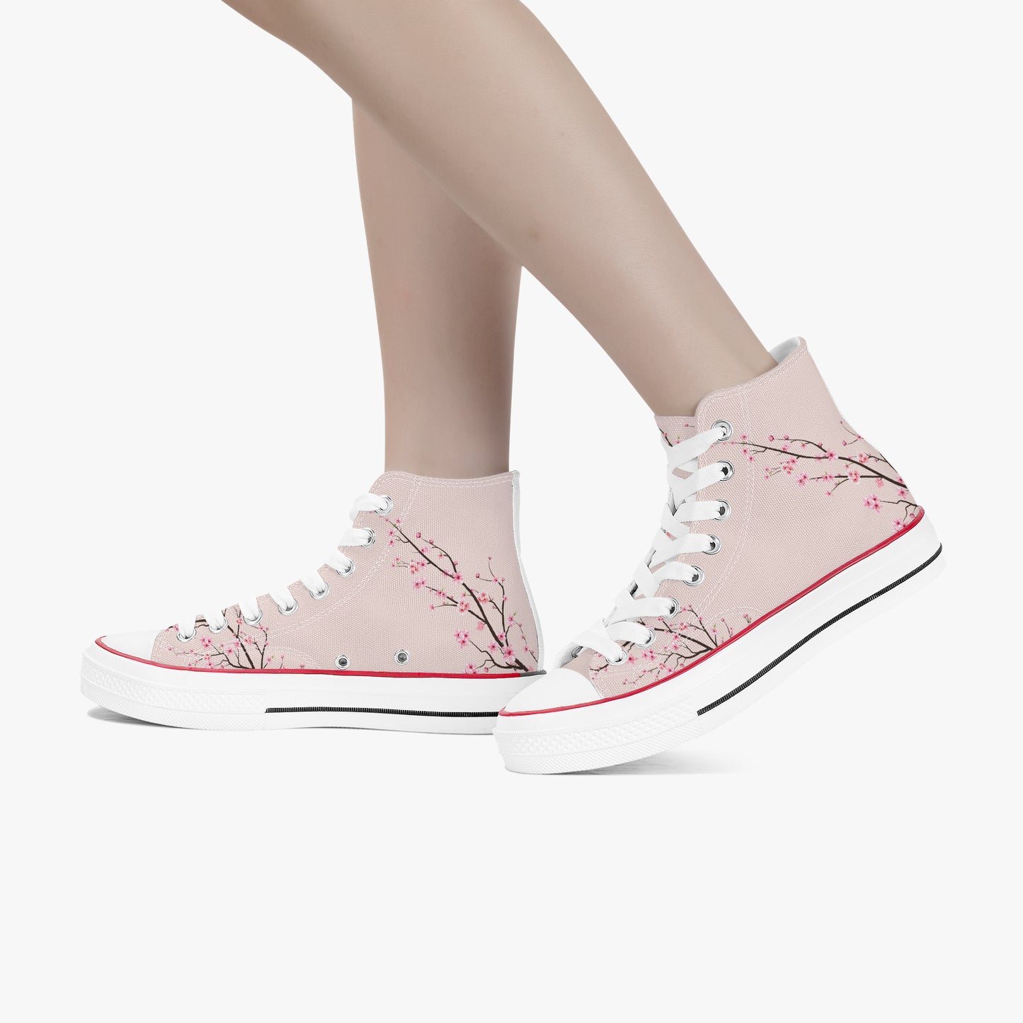 Pink high-top sneakers with floral design worn by a person on a white background