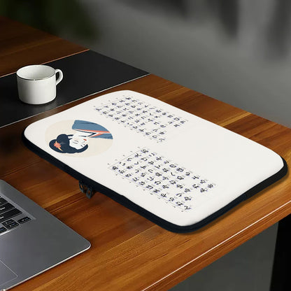 Desk with a laptop, mug, and decorative mat featuring text and a design on a wooden surface.