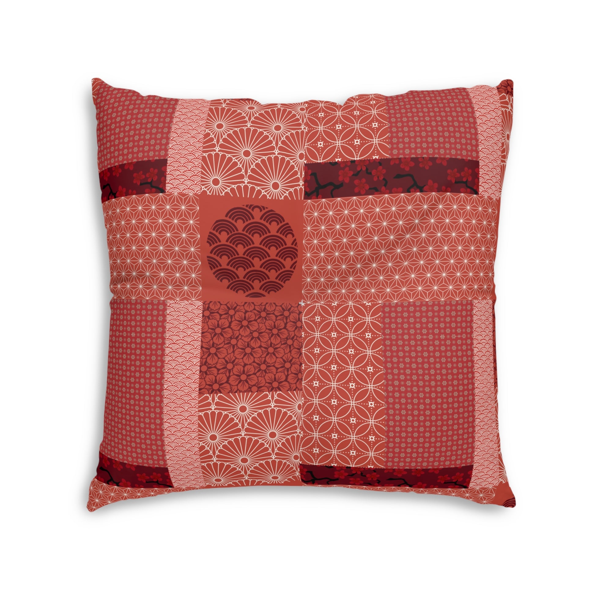 A square decorative throw pillow featuring a patchwork design of various red and pink Japanese-style patterns, including waves, dots, and geometric motifs, set against a plain white background.