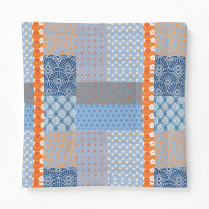 Patchwork pattern with blue, orange, and gray colors on a white background. Heritage Cotton