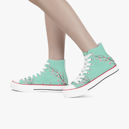 Teal high-top sneakers with floral design worn by a person on a white background