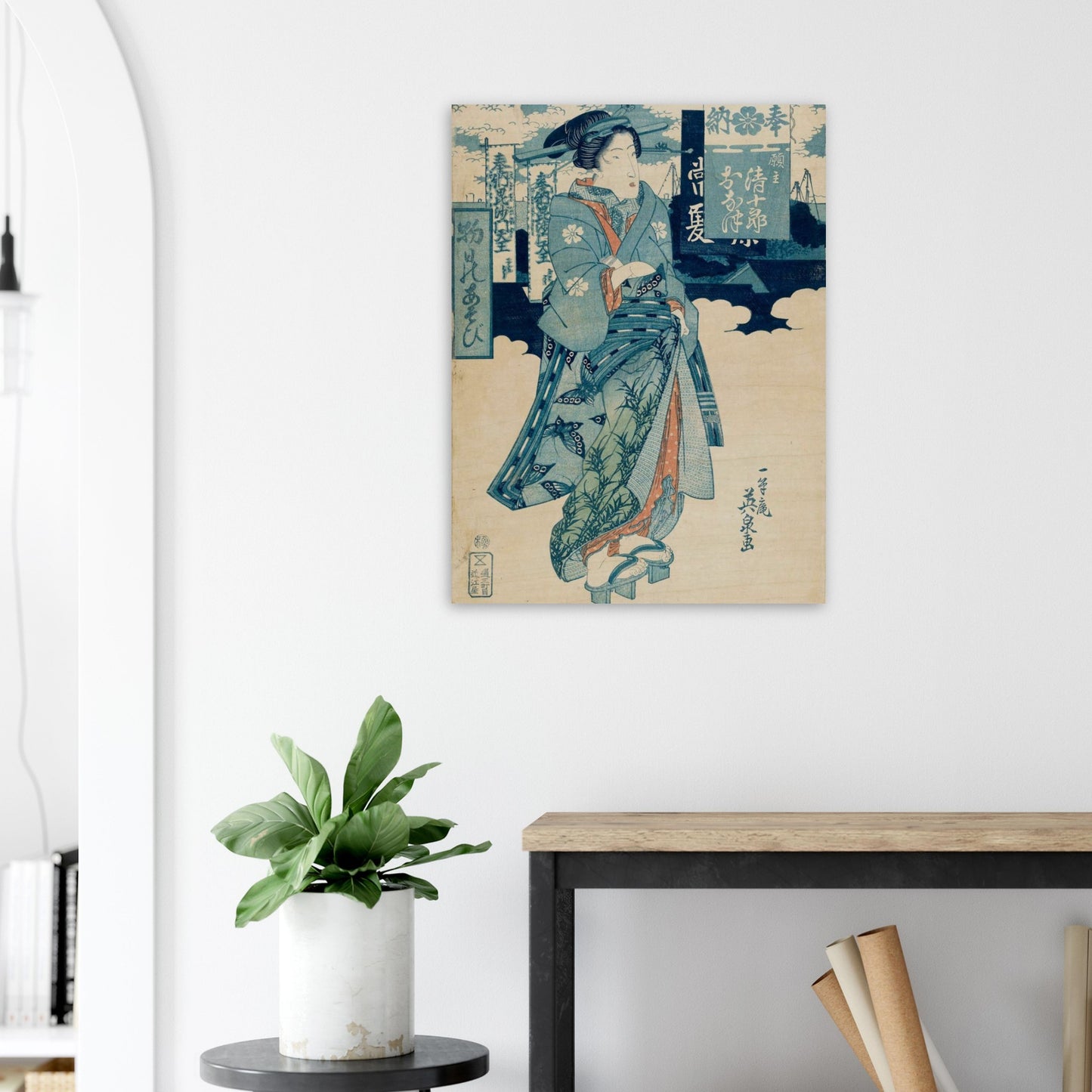 Canvas print of a traditional Japanese artwork on a wall above a desk with a plant.