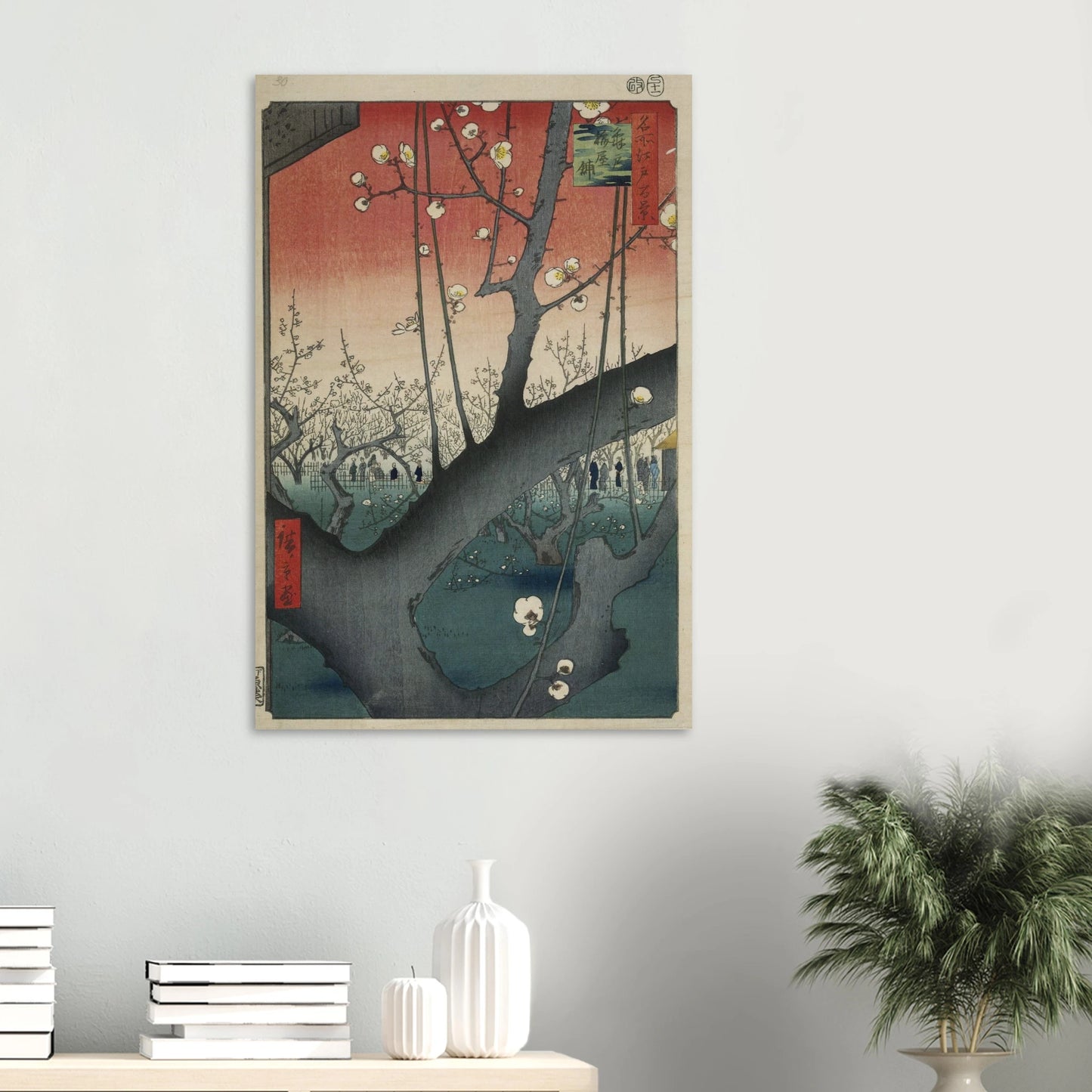 Framed artwork of a cherry blossom tree on a wall with decorative items below.