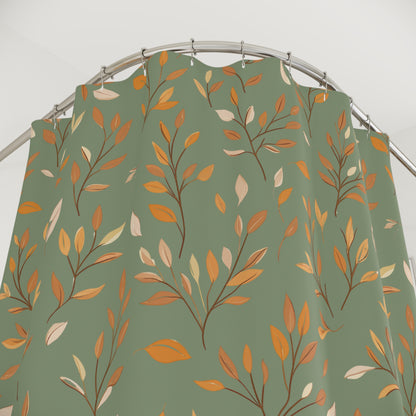 A sage green shower curtain featuring an all-over autumn leaf pattern in orange, mustard, and cream, hanging from a curved silver metal rod.