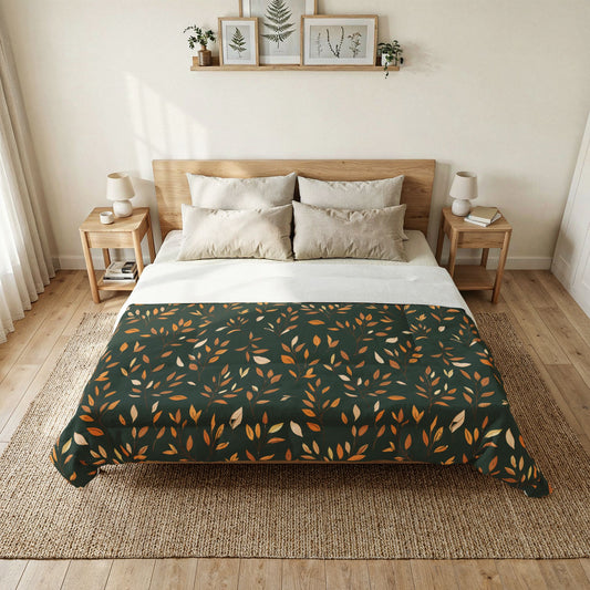 A neatly made bed in a bright, minimalist bedroom, featuring a dark green comforter with an orange and beige leaf pattern, styled with neutral-toned pillows and a wooden bed frame.