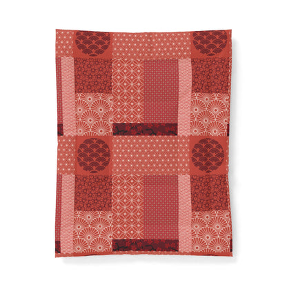 Red quilt with patterned blocks on a white background. Cotton Heritage