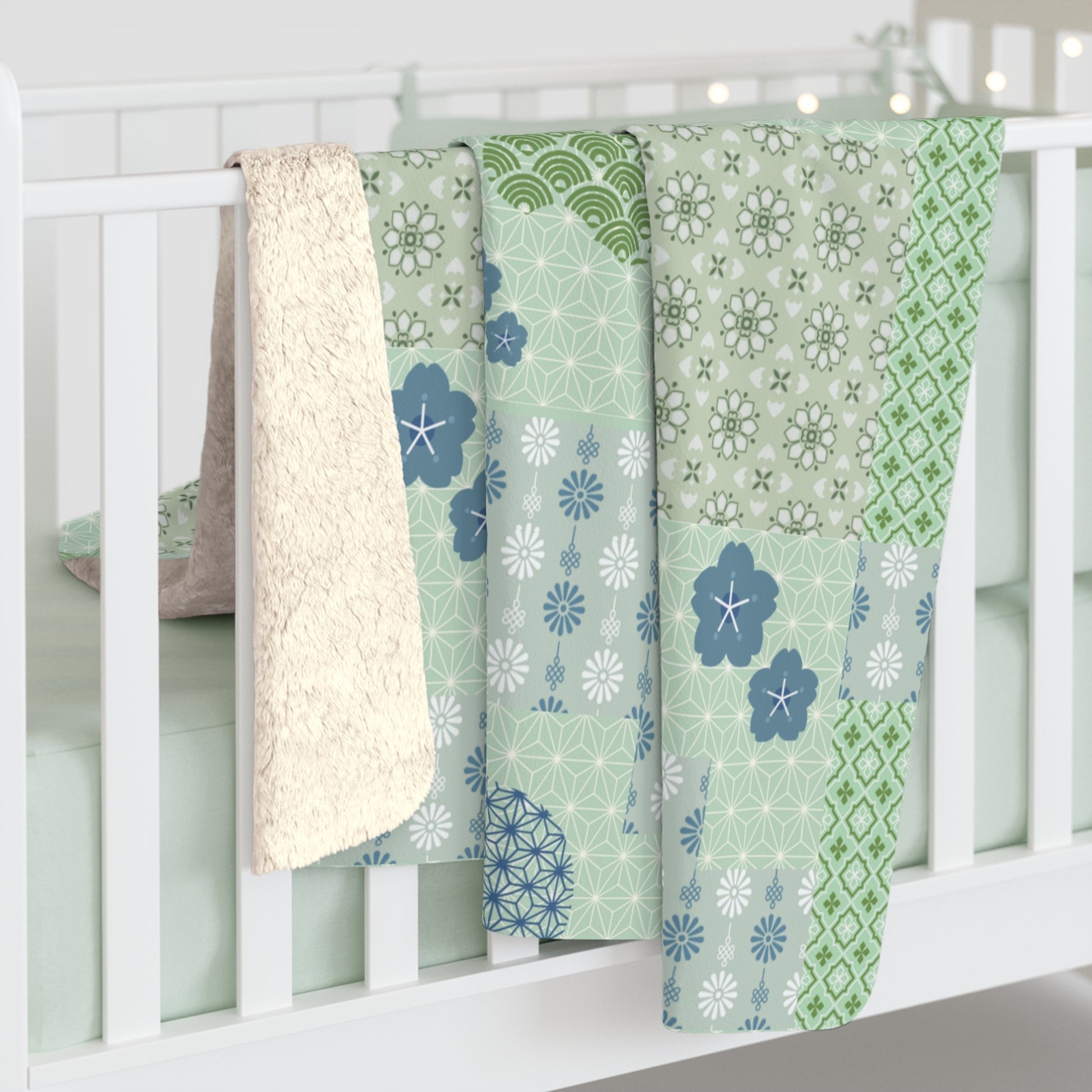 Three patterned baby blankets draped over a crib with a white background