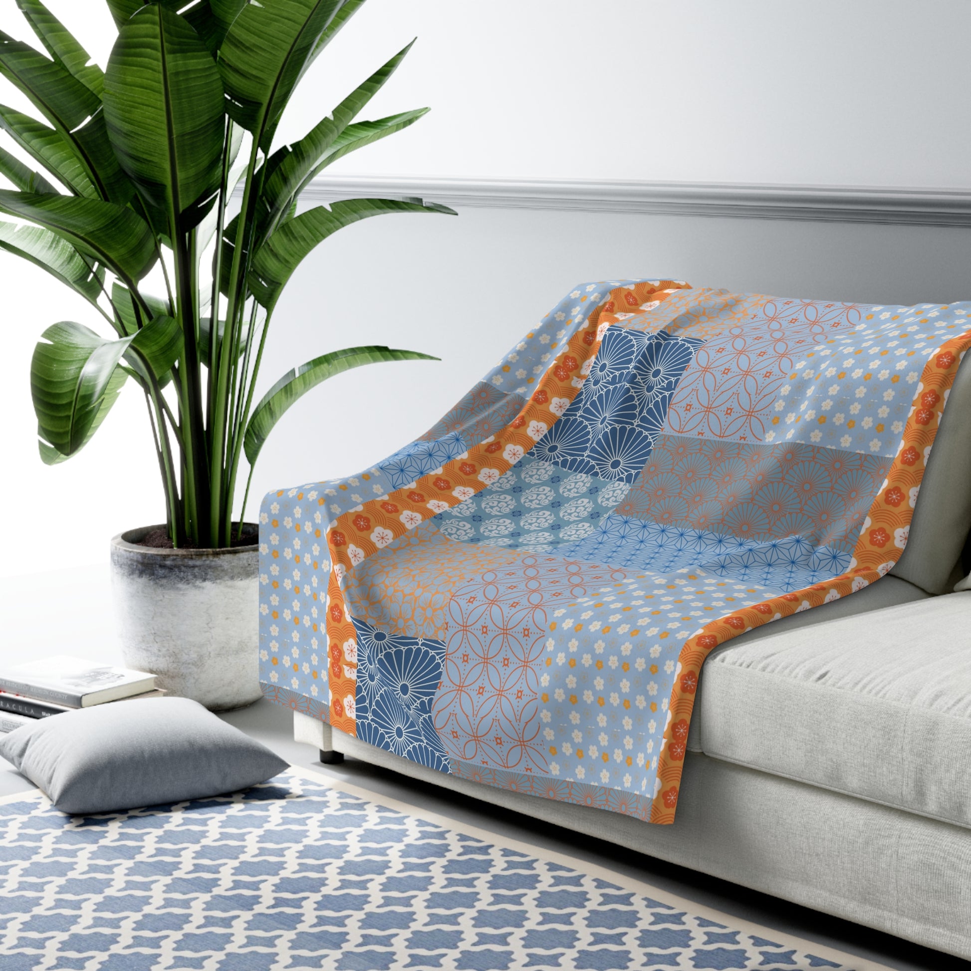 Sofa with a patterned cover in a living room setting with a plant and rug.