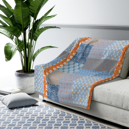 Sofa with a patterned cover in a living room setting with a plant and rug.
