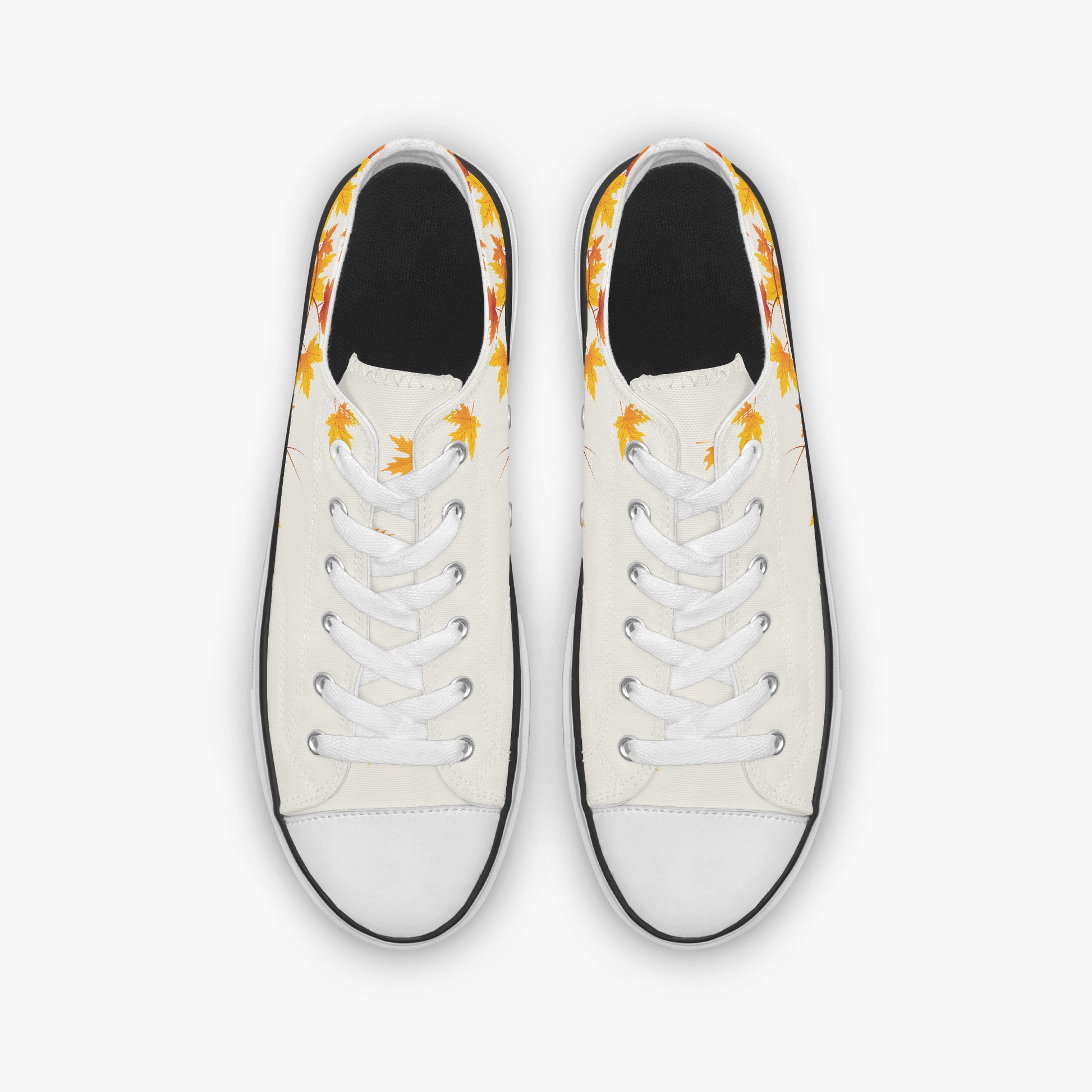 A pair of low-top canvas sneakers shown from a top-down view. The shoes feature an off-white canvas upper with a black rubber toe cap and sole edge, white laces, and a yellow and orange flame pattern printed around the collar.