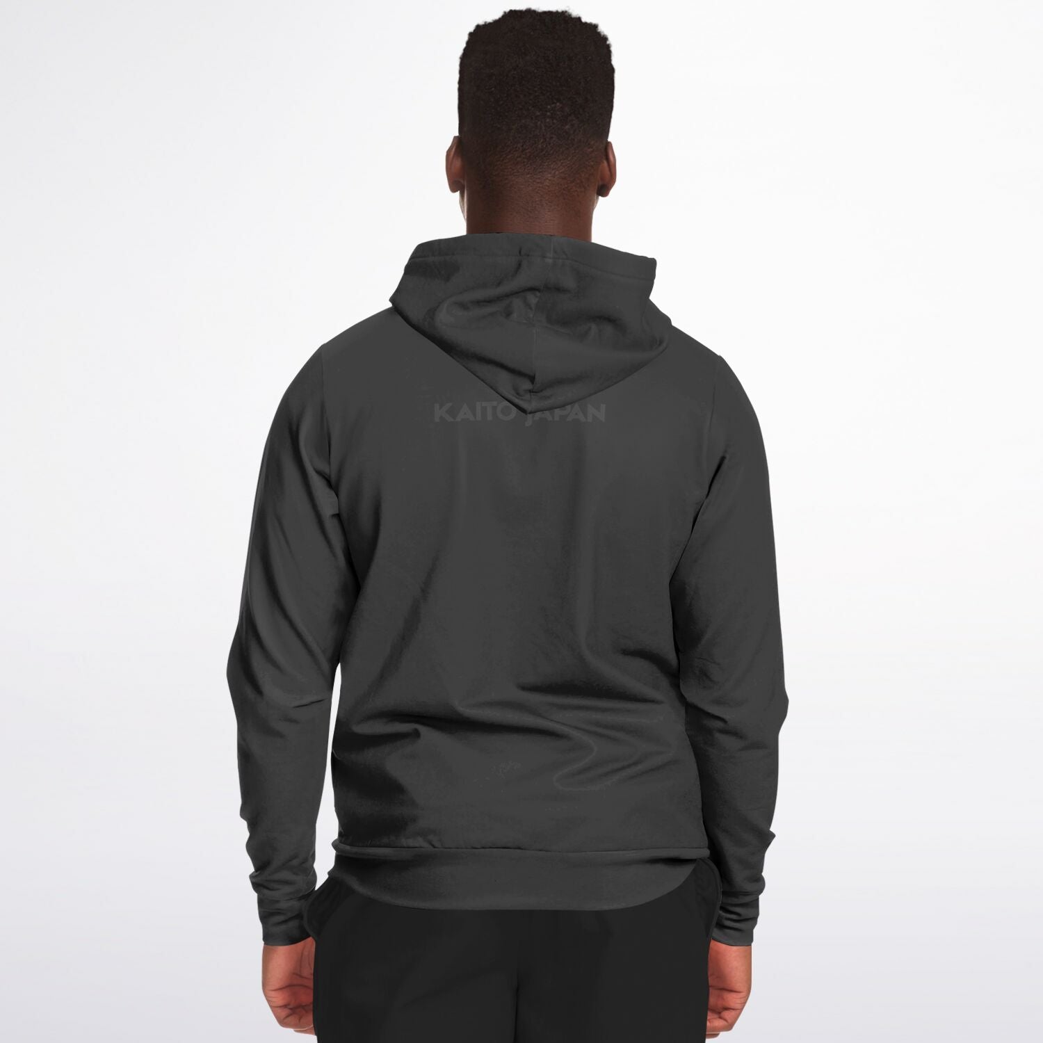 A man viewed from behind wearing a dark gray hooded sweatshirt with a subtle 'KAITO JAPAN' logo printed on the back, set against a plain white studio background.