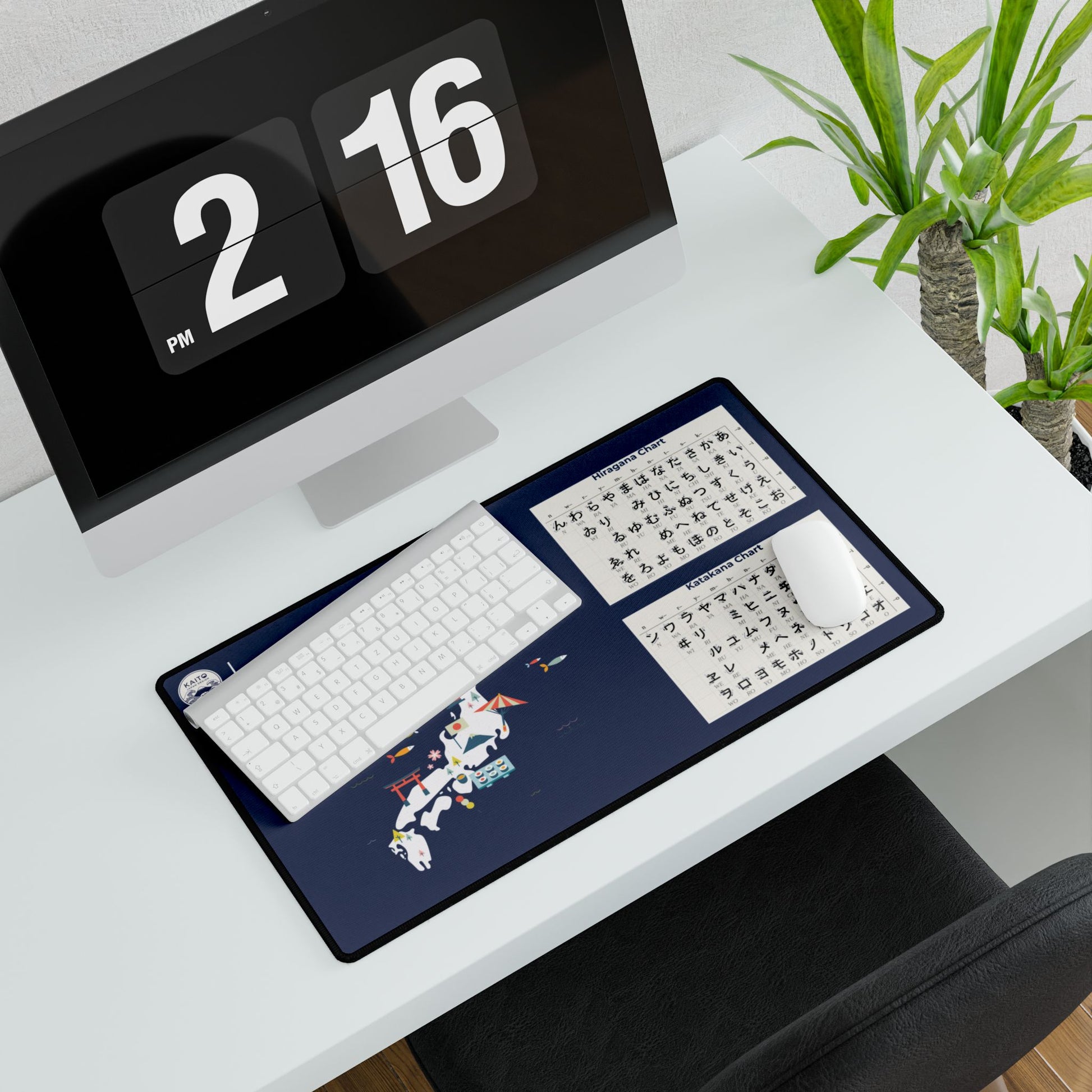 Desk setup with a large mouse pad featuring Japanese text and a dragon design, next to a computer monitor displaying '2 16'.