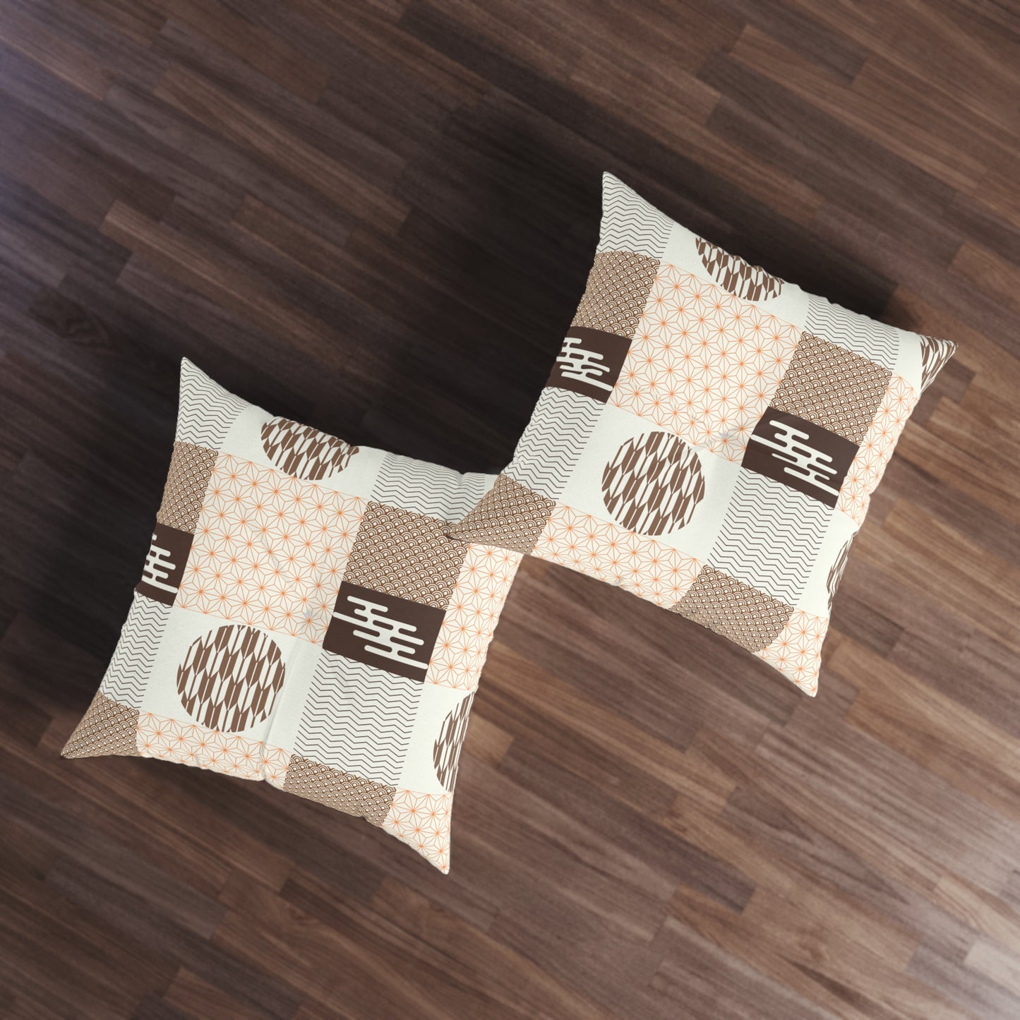 Two square throw pillows with a brown, beige, and white patchwork pattern featuring geometric and wavy motifs, displayed on a dark wood floor.