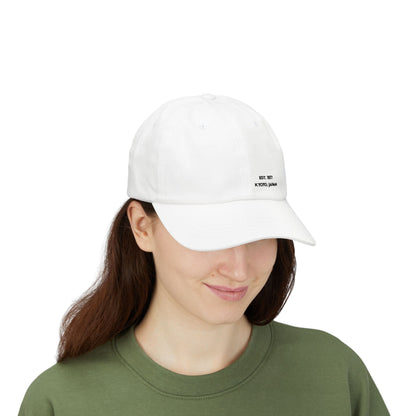 Person wearing a white cap with an embroidered design on a white background