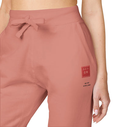 Pink jogger pants with a logo on a white background