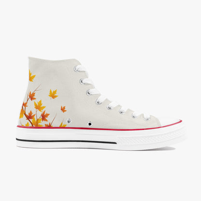 A high-top canvas sneaker in off-white, decorated with a pattern of orange and yellow autumn maple leaves on the side. It features white laces, metal eyelets, a red stripe along the edge of the white rubber toe cap, and a black stripe along the midsole.