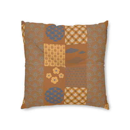 A square decorative throw pillow featuring a patchwork design of traditional Japanese-inspired patterns in warm brown, beige, and muted blue-gray, shown against a plain white background.