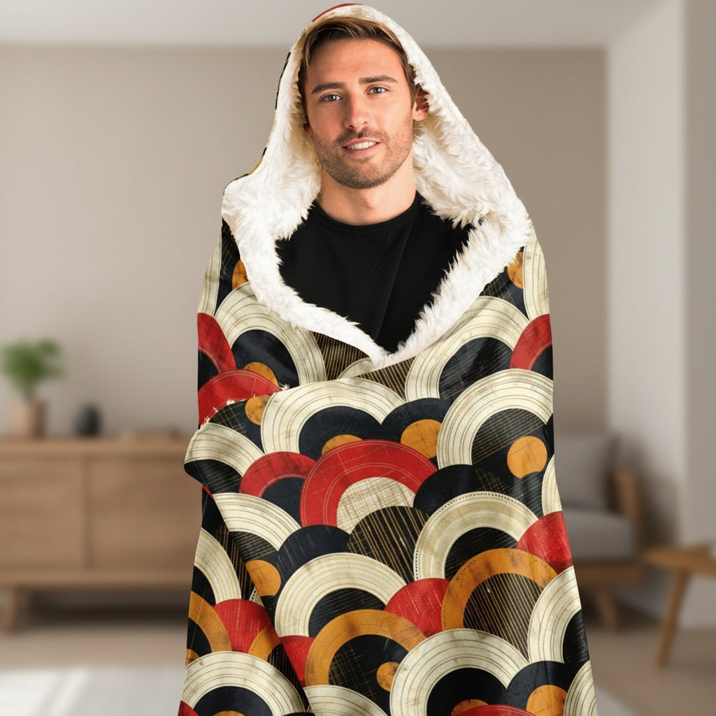 Man wearing a colorful patterned blanket with a hood on a white background