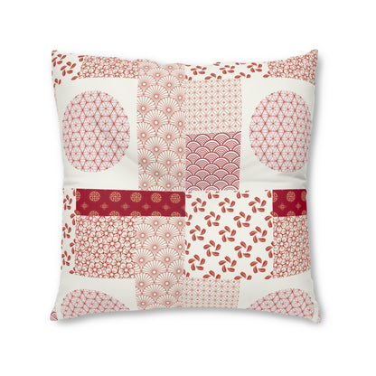 A square decorative throw pillow featuring a patchwork design of traditional Japanese-inspired patterns in red and pink on an off-white background, isolated on a white studio background.