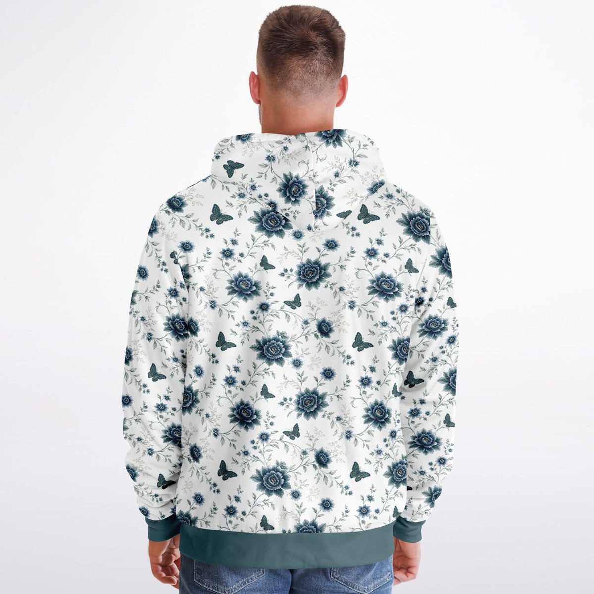 A man viewed from behind wearing a white hooded sweatshirt with a dark blue floral and butterfly pattern, paired with blue jeans, against a plain white background.