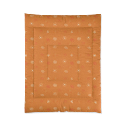 An orange quilted comforter or mattress protector featuring a repeating pattern of small white and pink floral motifs, shown flat against a white background.