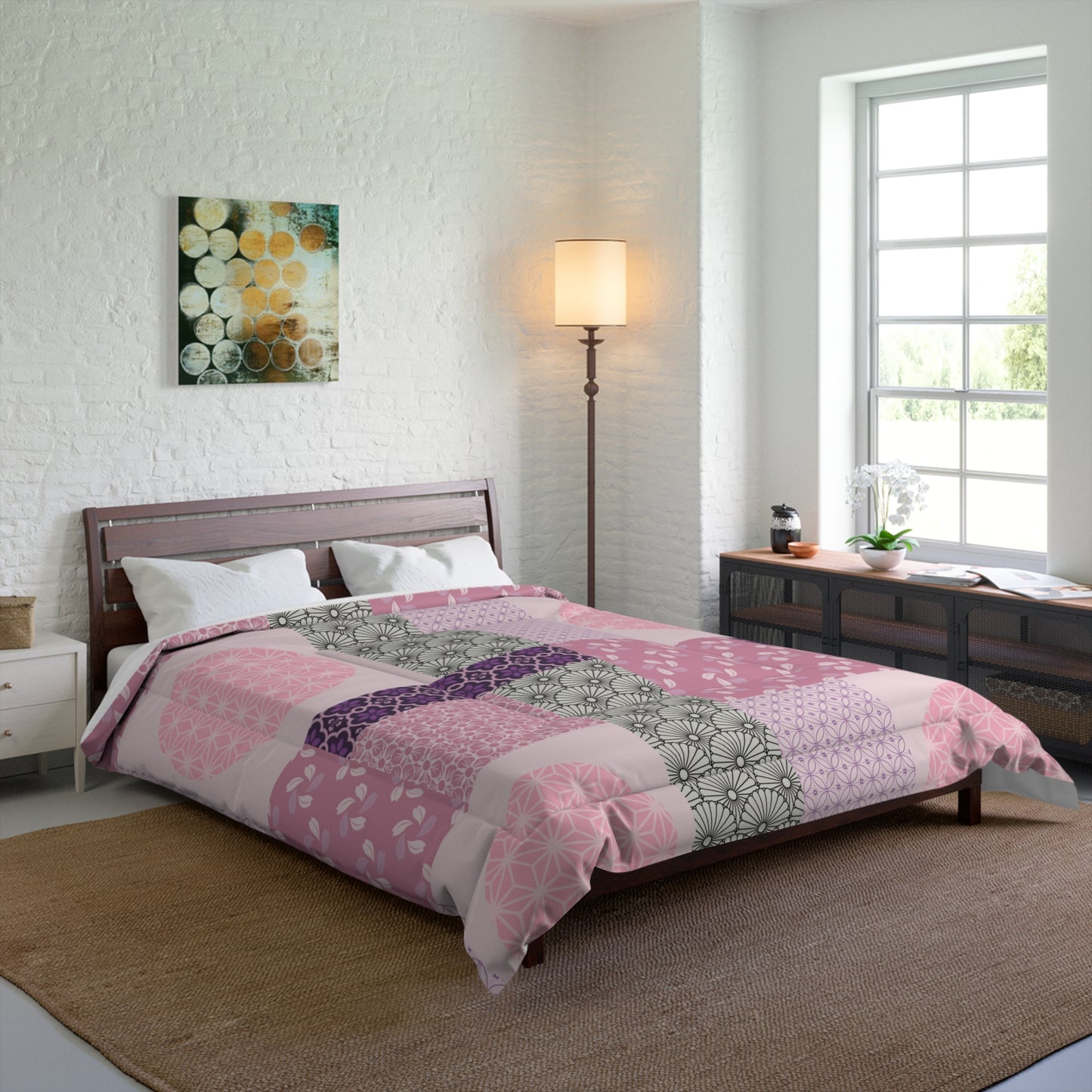 Bedroom with a bed featuring a pink and purple patterned comforter, a lamp, and a window.