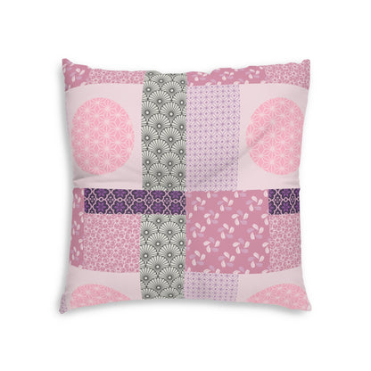A square decorative throw pillow featuring a patchwork design of various pink, purple, and gray geometric and floral patterns on a white background.