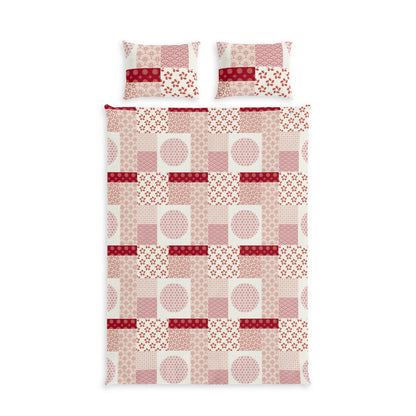 A bedding set featuring a patchwork quilt and two matching pillowcases with a geometric patchwork pattern in shades of pink, red, and white.