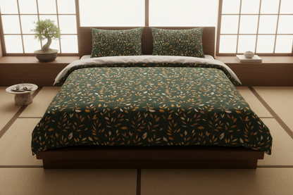 A Japanese-style platform bed dressed in a dark green patterned comforter and matching pillow shams, set in a tatami room with shoji screens and a small bonsai tree.