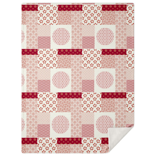 A high-angle, square photograph of a minimalist professional study featuring a dark walnut wood bench. Folded neatly on the bench is the Japanese Wagara Patchwork Blanket from Kaito Japan Design. The blanket features a striking, high-contrast patchwork of traditional motifs like Seigaiha waves and Asanoha hemp leaves in a bold red and white palette. Natural morning light streams from a side window, highlighting the crisp patterns and creating a vibrant yet orderly atmosphere.