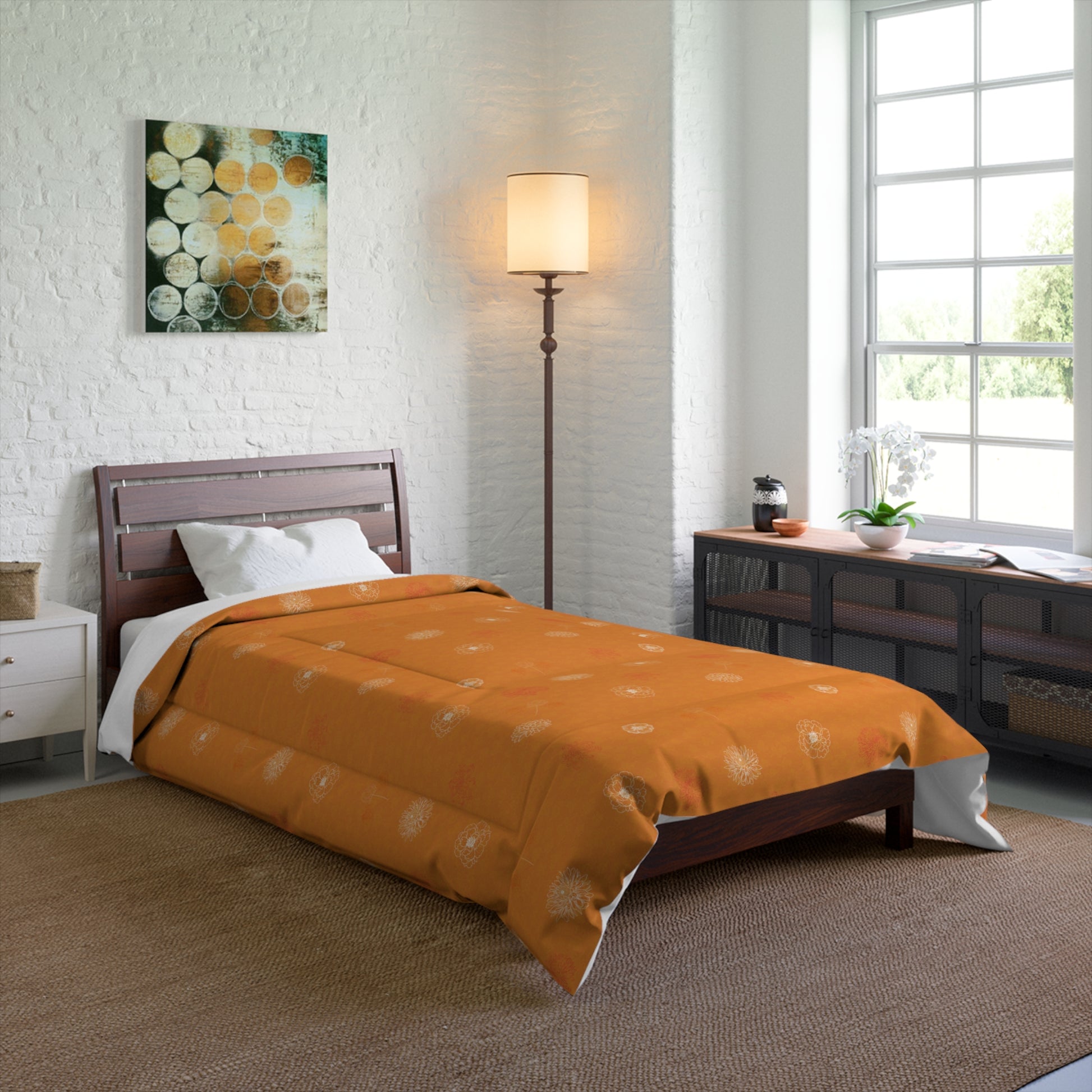 An orange patterned comforter on a wooden bed frame in a bright, modern bedroom setting with a floor lamp, window, and dresser.