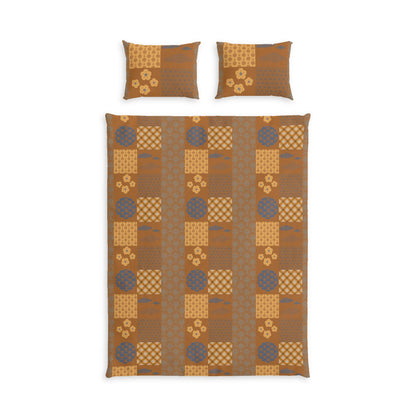 A bedding set featuring a patchwork quilt and two matching pillowcases in earthy brown, tan, and muted blue-gray tones, displayed on a clean white background.