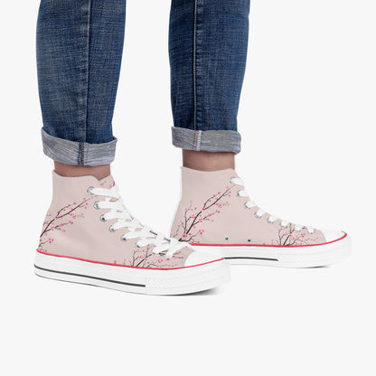 Pink high-top sneakers with floral design worn with rolled-up jeans on a white background