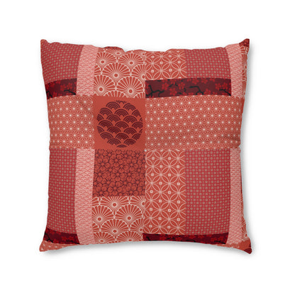 A square decorative throw pillow featuring a patchwork design of various red and pink Japanese patterns, including houndstooth, waves, and geometric motifs, set against a plain white background.