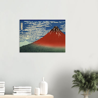 Framed artwork of Mount Fuji on a white wall with decorative items below.