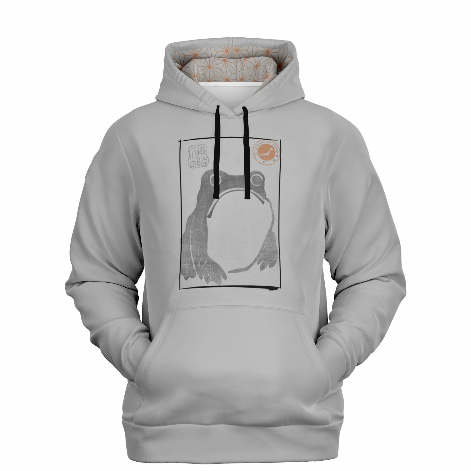 A light gray pullover hoodie with a black drawstring hood, featuring a central graphic print of a frog inside a rectangular frame with a small orange sun illustration in the upper right. The hoodie is displayed on a clean white background.
