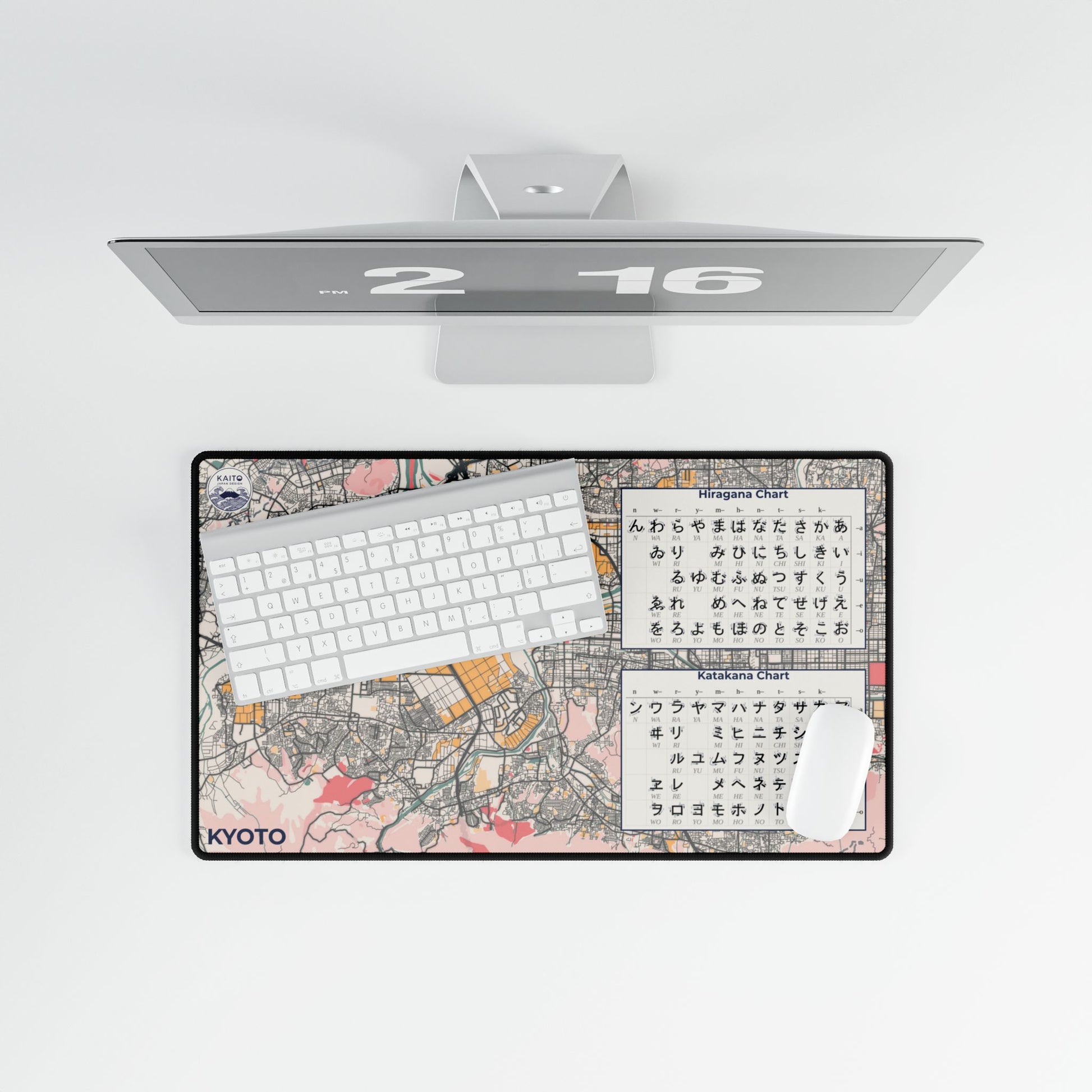 Desk setup with a monitor, keyboard, and mouse pad featuring a map design and text.