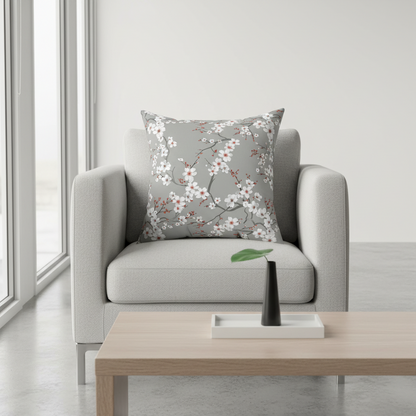 Gray armchair with a floral-patterned pillow in a minimalistic living room.