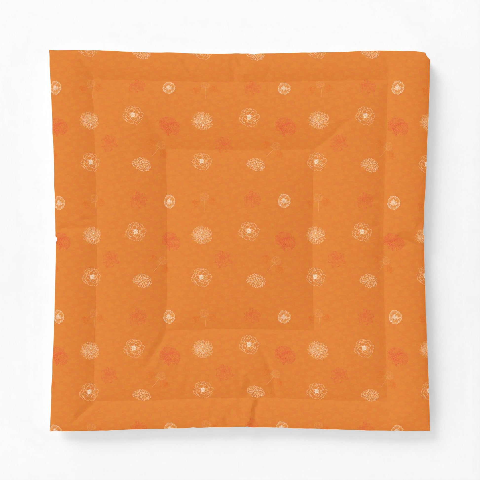 An orange square fabric item, likely a quilt or cushion cover, featuring a subtle pattern of small white and muted red floral motifs, displayed flat against a clean white background.