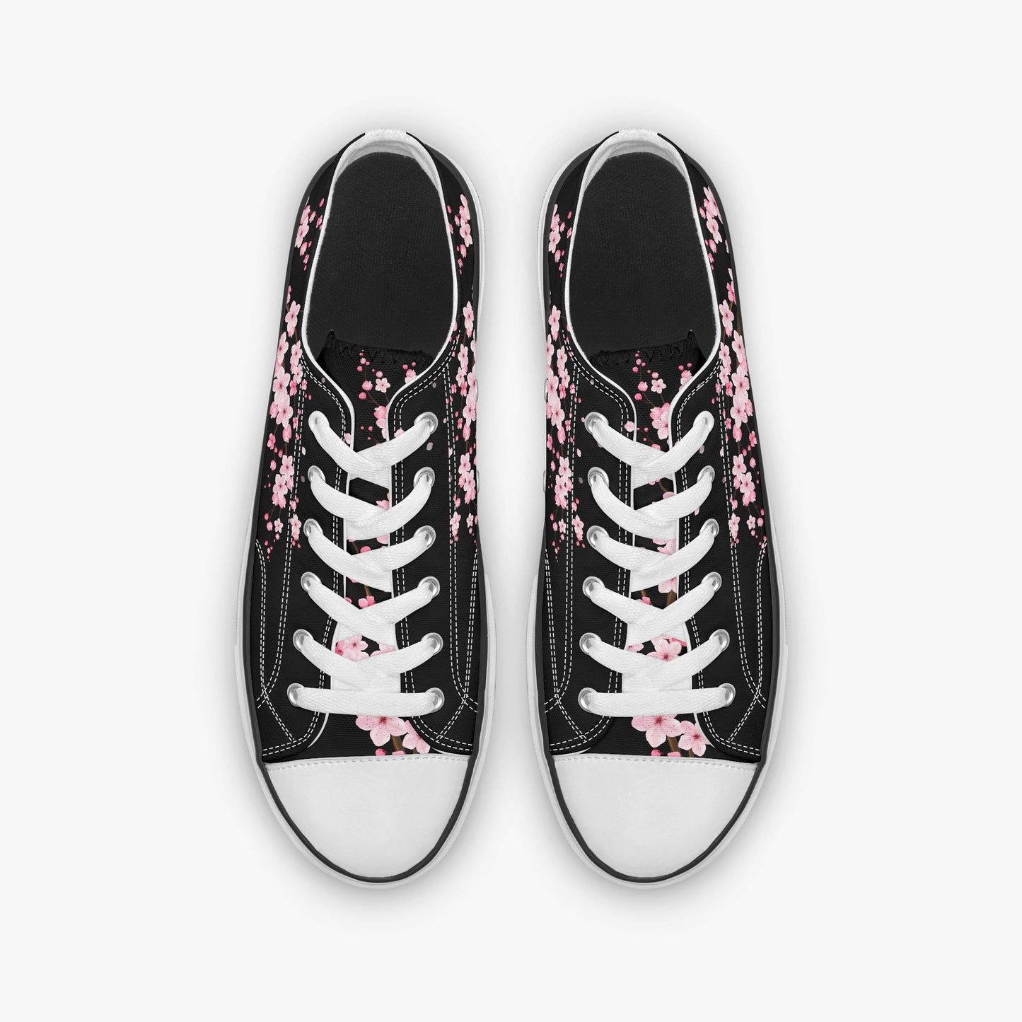 Black sneakers with pink floral patterns on a white background
