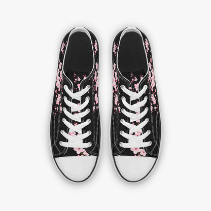 Black sneakers with pink floral patterns on a white background