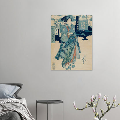 Traditional Japanese artwork on a wall above a bed with a side table and decorative branch.