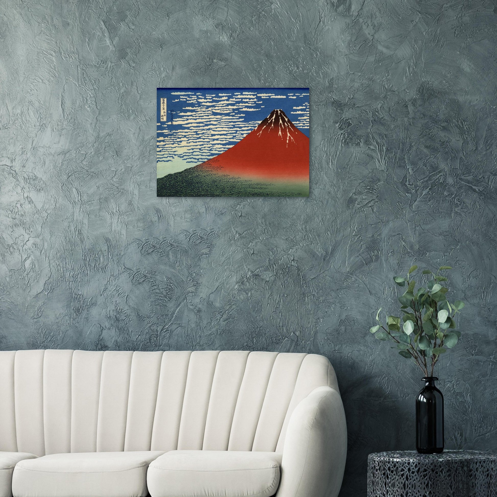 Framed artwork of a mountain on a gray wall above a white sofa.