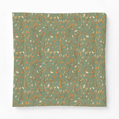 A square fabric item, likely a pillowcase or scarf, featuring an all-over botanical pattern of delicate branches and leaves in warm gold, brown, and cream tones on a muted sage green background.