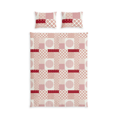 A bedding set featuring a duvet cover and two matching pillowcases with a patchwork quilt pattern in shades of pink, red, and white.