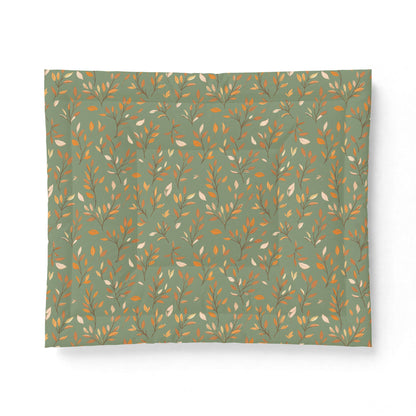 A square fabric item, likely a pillowcase or small blanket, featuring a repeating botanical pattern of delicate branches with small leaves in warm orange, mustard, and cream on a muted sage green background.