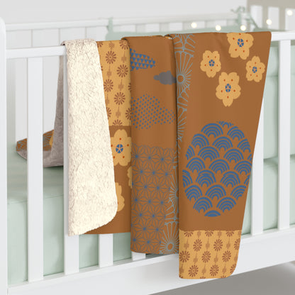 Three patterned blankets draped over a white crib with a neutral background